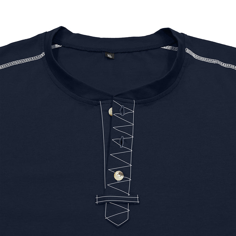 Close-up of a navy blue henley-style top with white geometric contrast stitching and a small metallic button at the placket, shown on a white background.