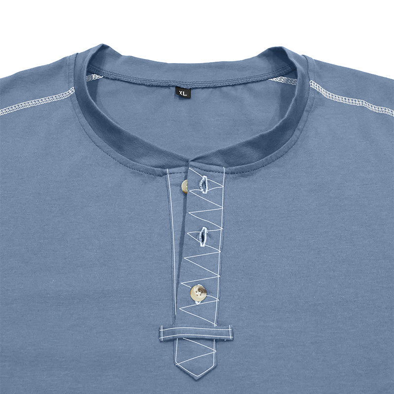 A close-up of a slate blue henley-style t-shirt featuring decorative white contrast stitching and three buttons on the chest, with a small black size label reading 'XL' inside the collar.